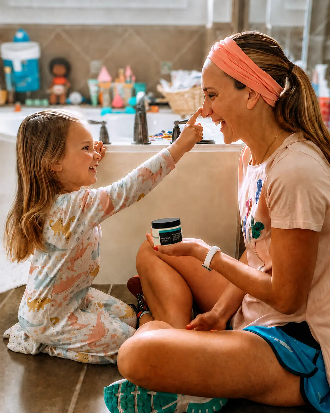 Mother and young daughter share a bathroom moment while she holds YEOUTH Day/Night Cream.