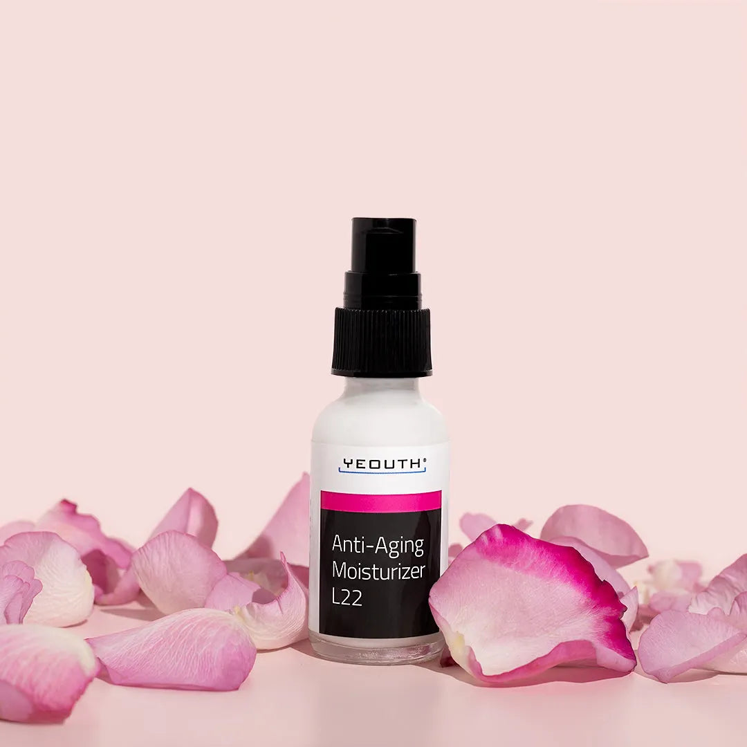 YEOUTH Anti-Aging Moisturizer L22 bottle surrounded by pink rose petals on a soft pink background.